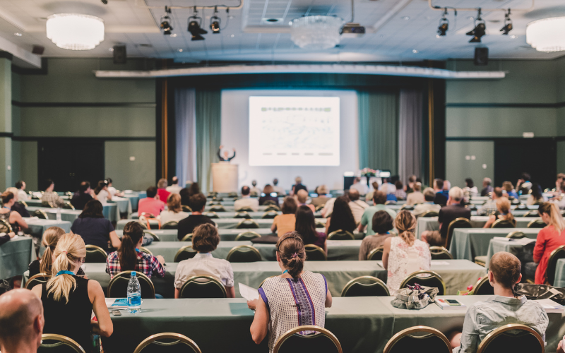 VKonSec corporate training session — a full conference hall of professionals attending an instructor-led security training with a presentation on screen
