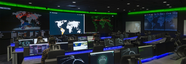 One Biotech company incident response retainer war room — a darkened SOC with analysts at blue-lit desks facing a wall of world threat maps and live dashboards