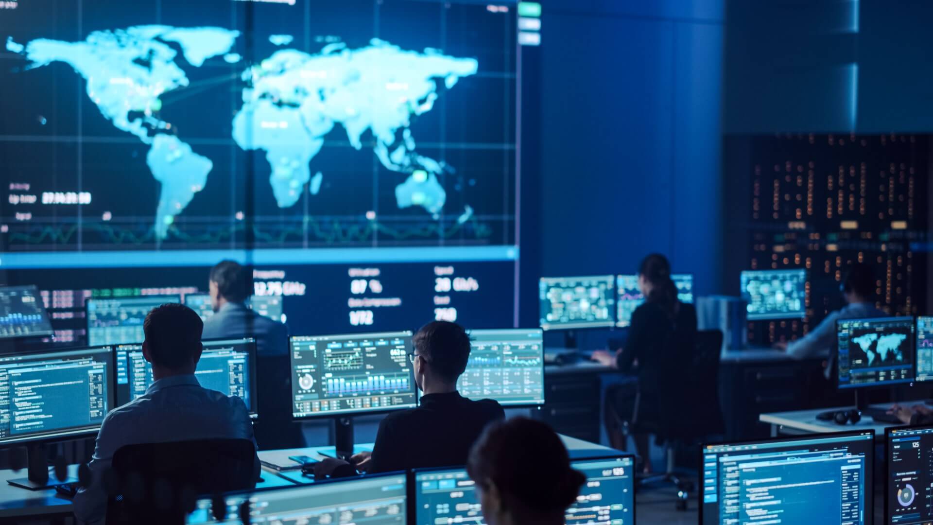 VKonSec security operations center — analysts monitoring a global threat map and live dashboards